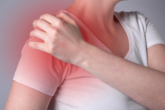 Red shoulder pain highlighting inflammation, white t-shirt, white woman, holding her shoulder