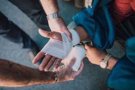 bandaged hand with people holding the hands from above, to show inflammation 
