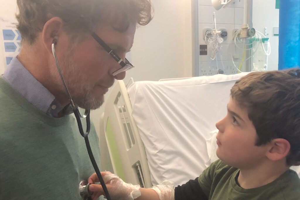 Alasdair Robertson with his son Felix in hospital with a stethoscope looking at each other