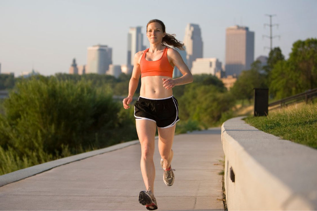 Healthy femal jogger in front of a summer skyline