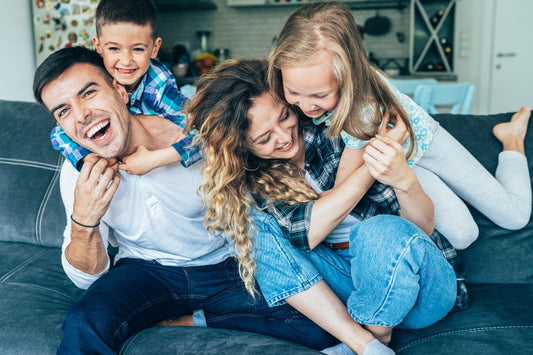 Energized family on a blue couch having beaten parental fatigue